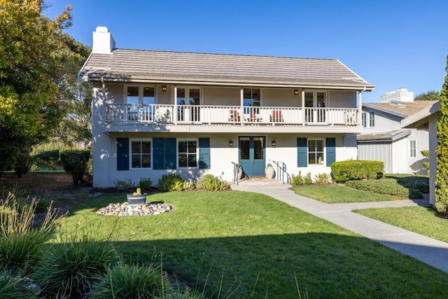 view of front of property featuring a front lawn and a balcony