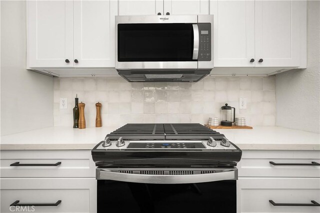 kitchen with white cabinetry, gas range, and backsplash