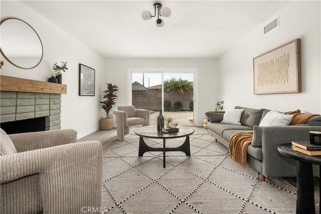 living room with light wood-type flooring and a fireplace