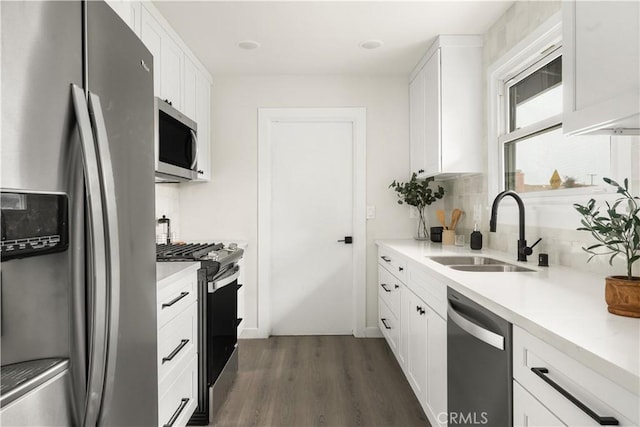 kitchen featuring dark wood-type flooring, stainless steel appliances, white cabinetry, and sink