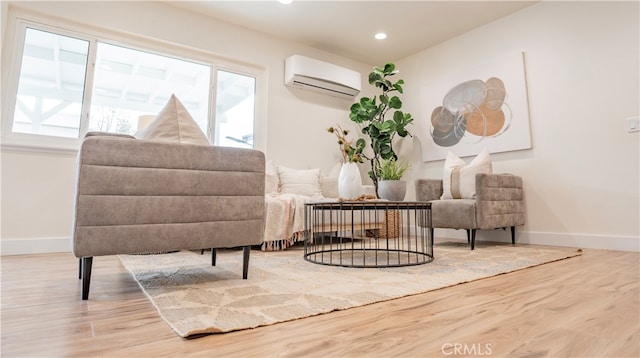 sitting room featuring a wall mounted AC and hardwood / wood-style floors