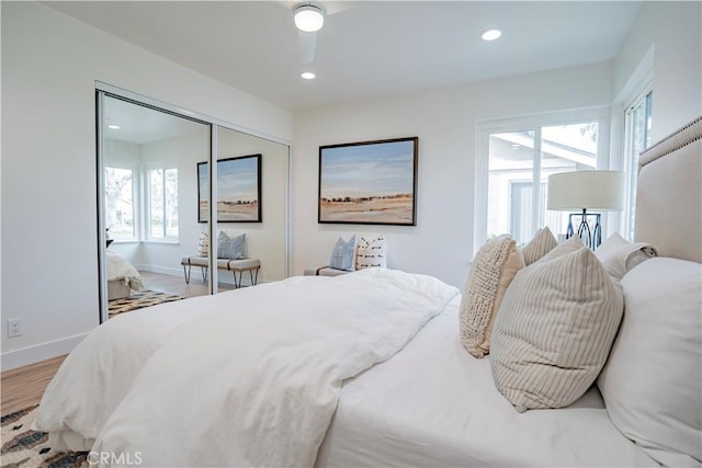 bedroom featuring ceiling fan, a closet, and light hardwood / wood-style flooring