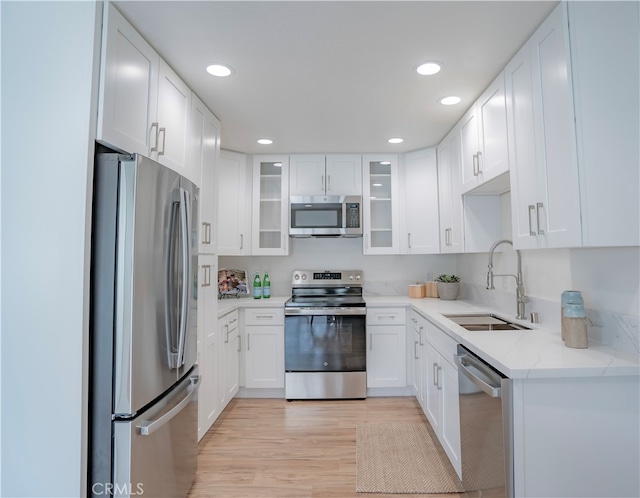 kitchen featuring light hardwood / wood-style floors, sink, white cabinets, and stainless steel appliances