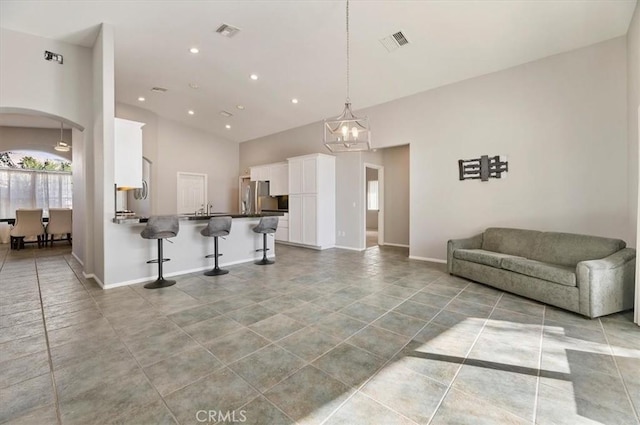 kitchen featuring dark countertops, open floor plan, white cabinetry, and visible vents