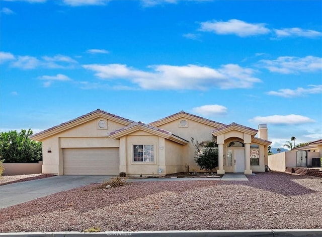 mediterranean / spanish house with an attached garage, concrete driveway, and stucco siding