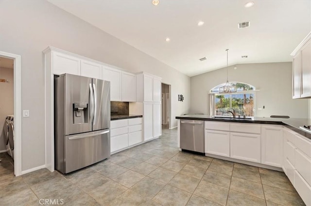 kitchen featuring stainless steel appliances, dark countertops, visible vents, washing machine and dryer, and white cabinetry