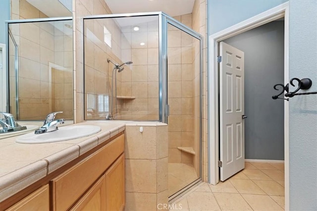 full bathroom with tile patterned flooring, vanity, and a shower stall