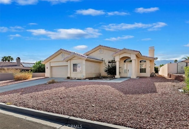 mediterranean / spanish-style home with a garage, concrete driveway, and stucco siding