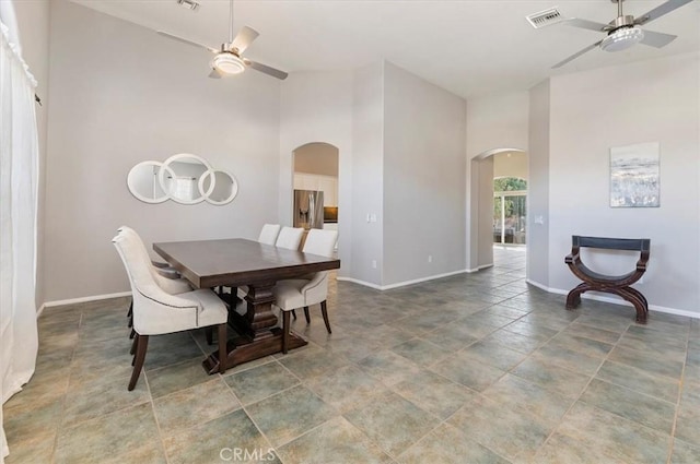 dining area featuring arched walkways, visible vents, and a ceiling fan