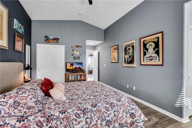 bedroom with ceiling fan, wood-type flooring, a closet, and vaulted ceiling