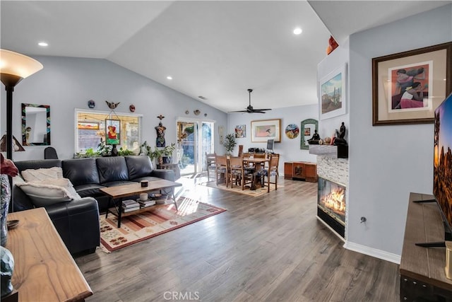 living room featuring ceiling fan, lofted ceiling, a fireplace, and hardwood / wood-style flooring