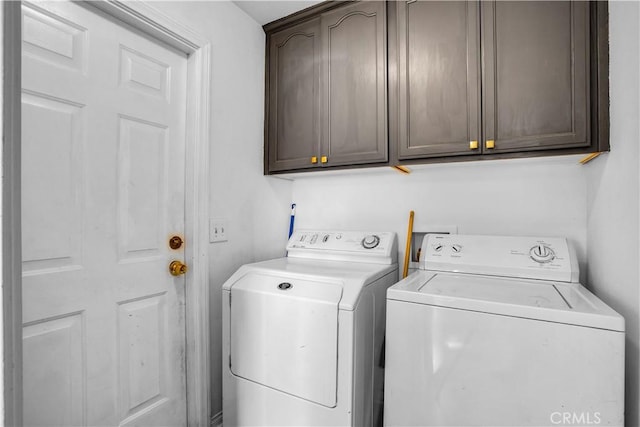 washroom with cabinets and washing machine and clothes dryer