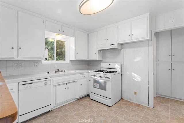 kitchen featuring white cabinetry, white appliances, tile countertops, and under cabinet range hood