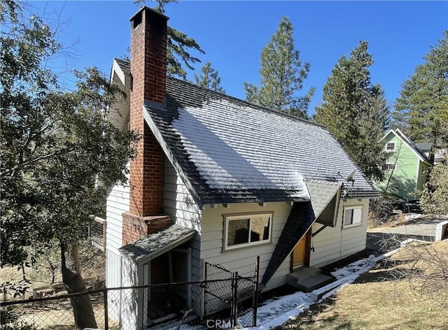 back of property featuring entry steps, fence, and a chimney