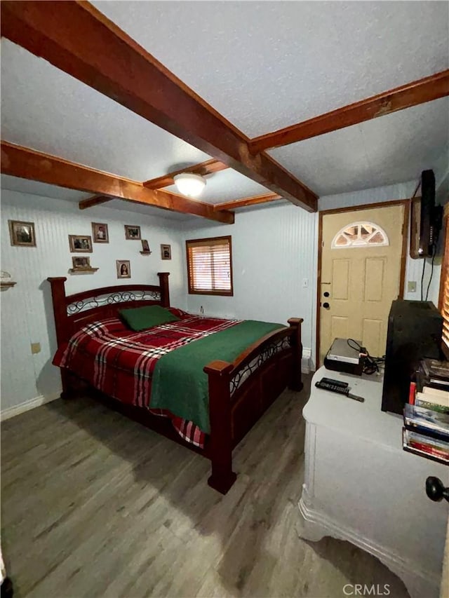 bedroom with ceiling fan, hardwood / wood-style floors, and beam ceiling