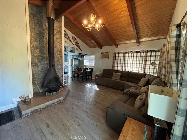 unfurnished living room with an inviting chandelier, hardwood / wood-style flooring, wooden ceiling, a wood stove, and beam ceiling