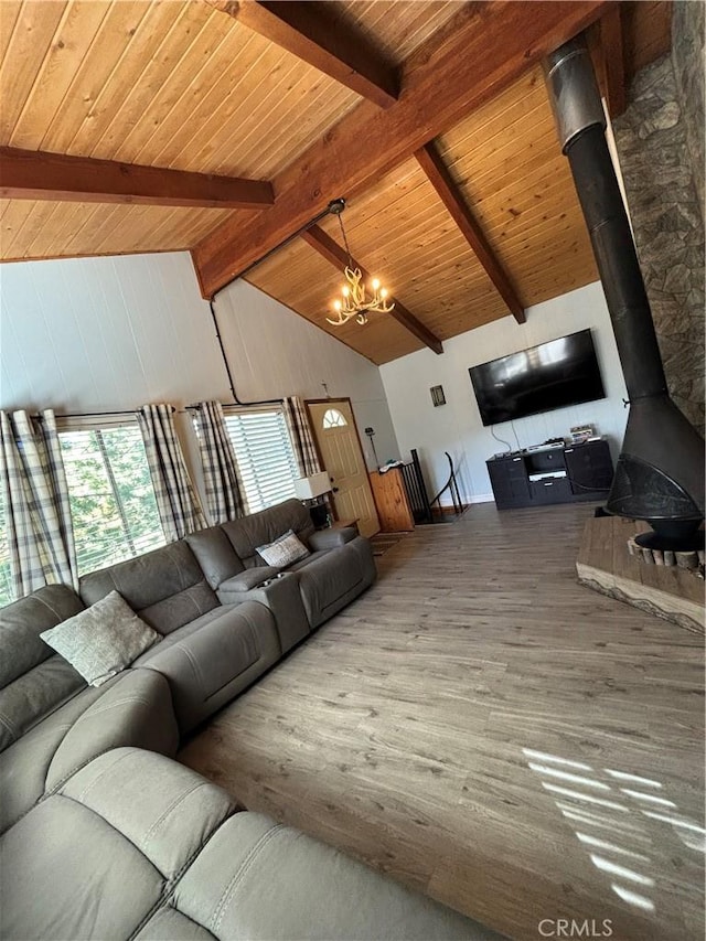 unfurnished living room featuring an inviting chandelier, hardwood / wood-style flooring, wooden ceiling, a wood stove, and beam ceiling