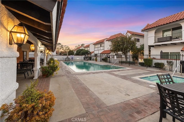 pool at dusk featuring a patio area