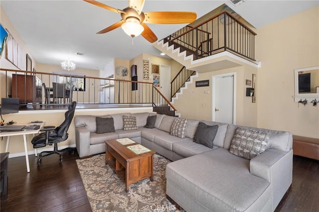 living room featuring dark wood-type flooring and ceiling fan with notable chandelier