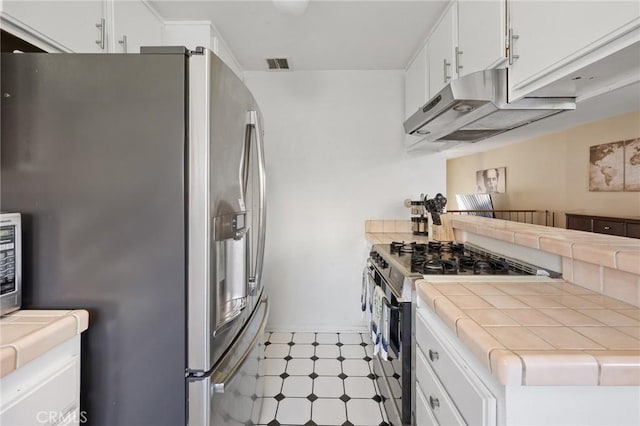 kitchen with white cabinetry, appliances with stainless steel finishes, and tile counters