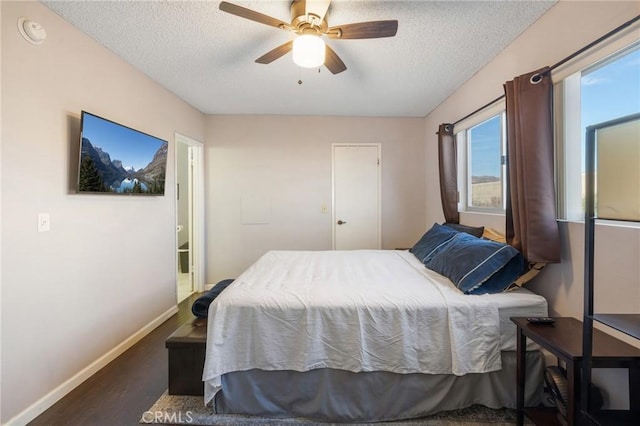 bedroom with ceiling fan, dark hardwood / wood-style floors, and a textured ceiling