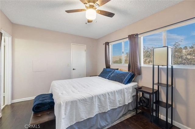 bedroom featuring ceiling fan, dark wood-type flooring, and a textured ceiling