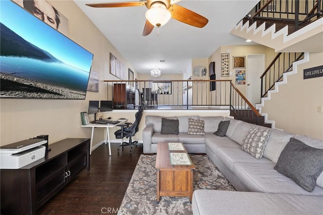 living room with dark wood-type flooring and ceiling fan with notable chandelier