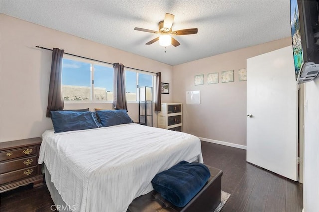 bedroom featuring ceiling fan, dark wood-type flooring, and a textured ceiling