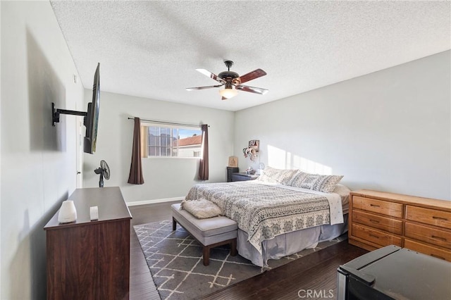 bedroom featuring ceiling fan, dark wood-type flooring, and a textured ceiling