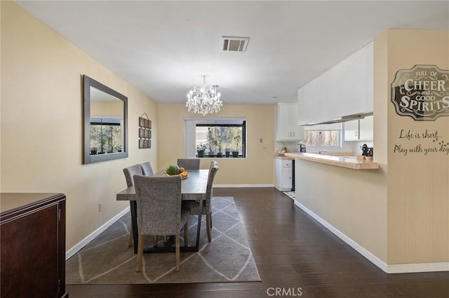 dining area with an inviting chandelier and dark hardwood / wood-style floors