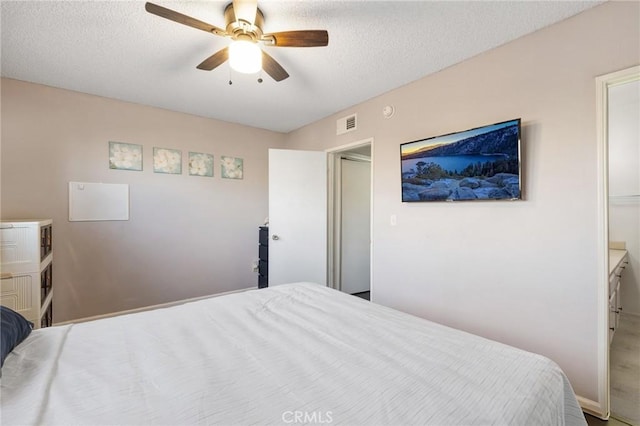 bedroom featuring ceiling fan and a textured ceiling