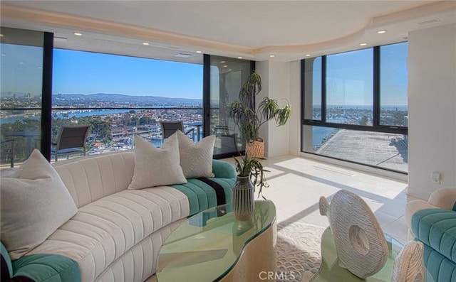 tiled living room with a water and mountain view, a wall of windows, and a healthy amount of sunlight