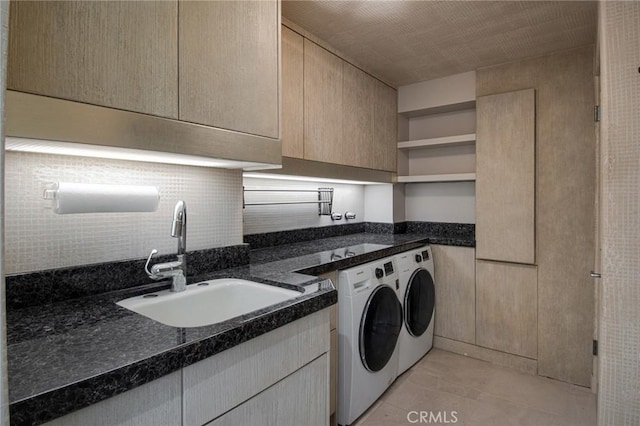 washroom with cabinets, light tile patterned floors, independent washer and dryer, and sink