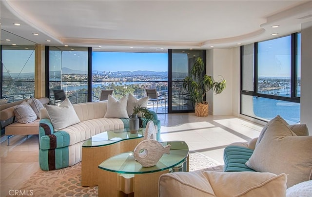 tiled living room featuring expansive windows and a water and mountain view