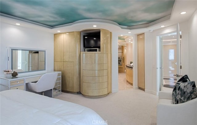 bedroom featuring light carpet and a tray ceiling