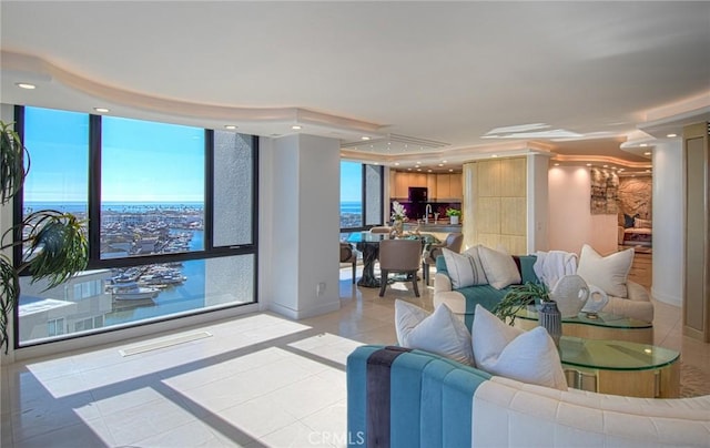 living room with a water view, light tile patterned floors, and a wall of windows