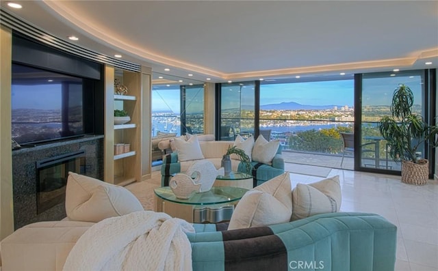 interior space featuring expansive windows, a high end fireplace, a mountain view, and built in features