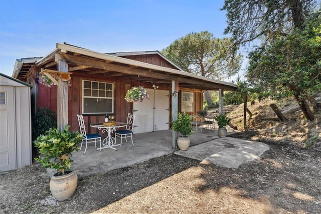 rear view of house featuring a patio area and a storage shed