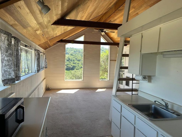 kitchen featuring lofted ceiling with beams, wood ceiling, sink, and white cabinetry