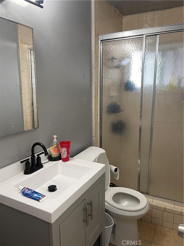 bathroom with toilet, tile patterned flooring, walk in shower, and vanity