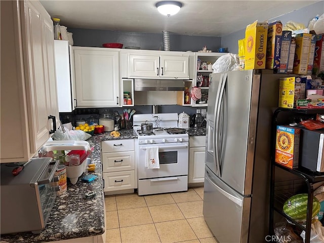 kitchen with stainless steel refrigerator with ice dispenser, backsplash, light tile patterned flooring, white gas range, and white cabinets