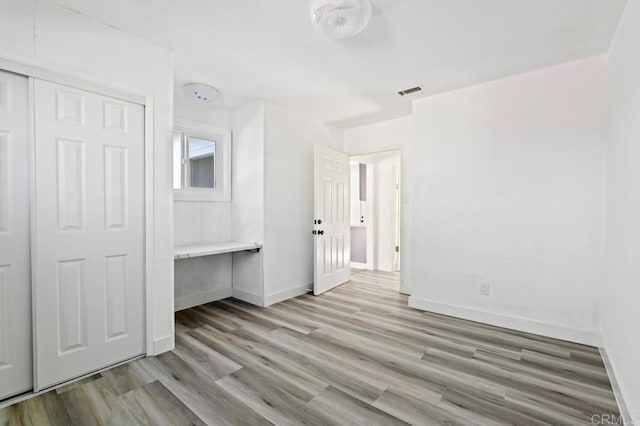 unfurnished bedroom with light hardwood / wood-style floors and a closet