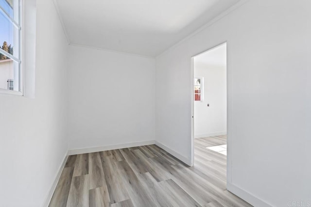 unfurnished room featuring ornamental molding and light wood-type flooring