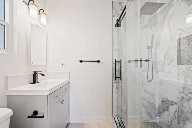 bathroom featuring vanity, a shower with door, and toilet