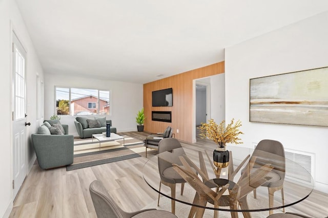 living room featuring light hardwood / wood-style flooring and wood walls