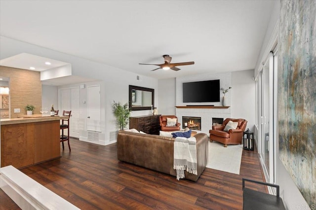 living room with recessed lighting, dark wood-style flooring, a fireplace, a ceiling fan, and baseboards