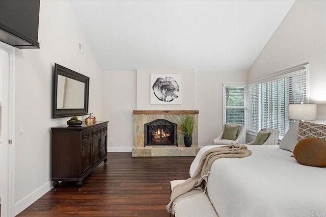 bedroom with baseboards, visible vents, dark wood-type flooring, a fireplace, and high vaulted ceiling