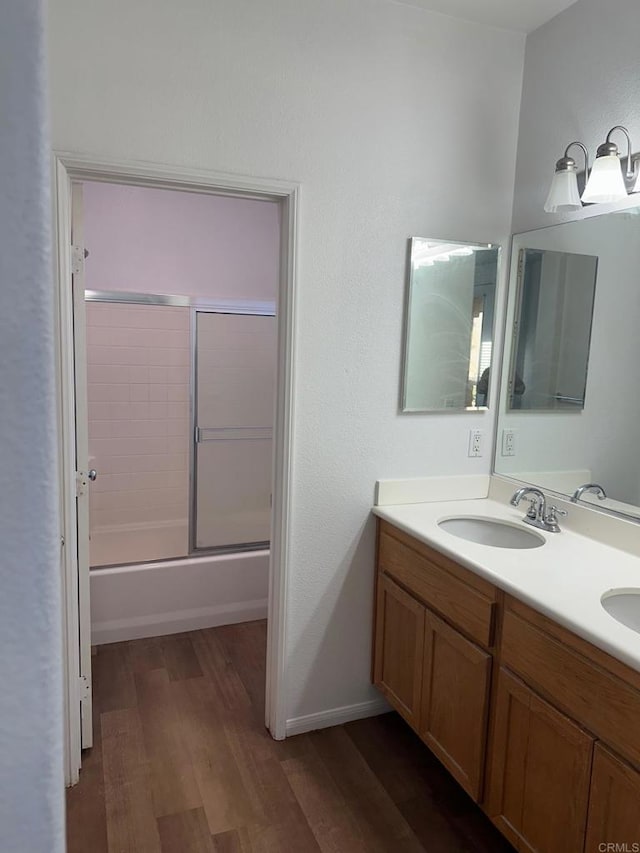 bathroom with enclosed tub / shower combo, wood-type flooring, and vanity