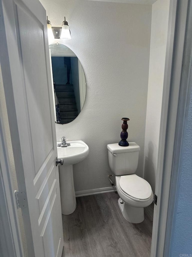 bathroom featuring toilet and wood-type flooring