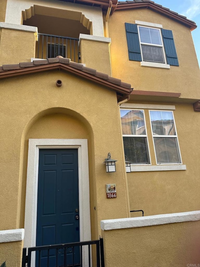 view of exterior entry featuring a balcony